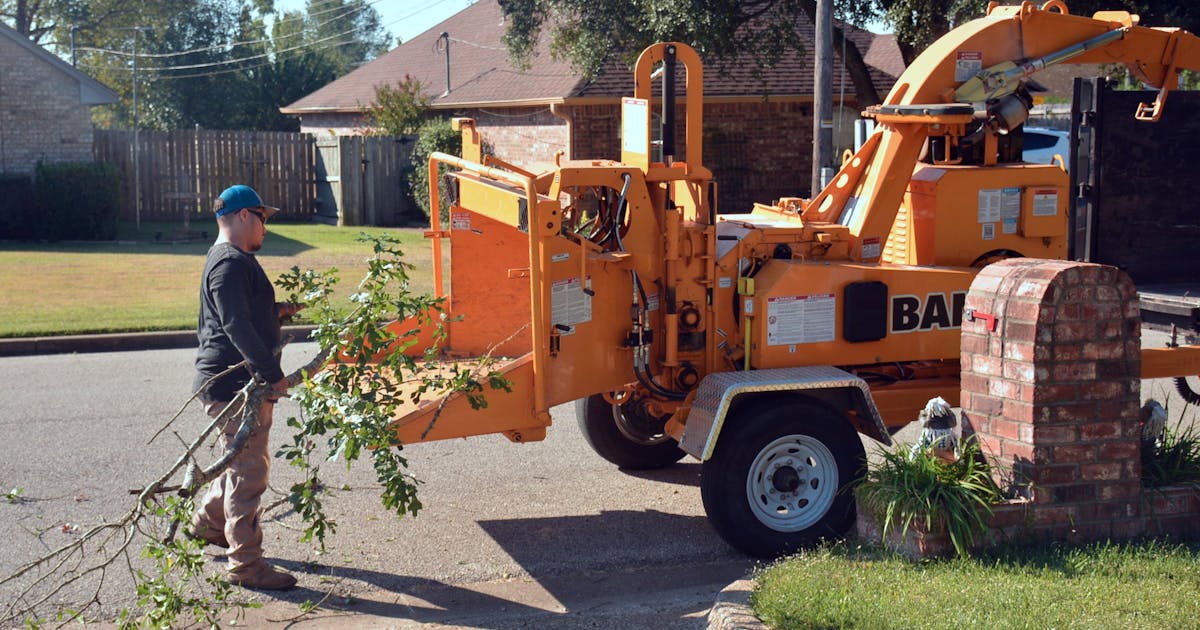 Worker operating a wood chipper